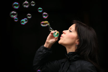 Portrait of a beautiful young woman blowing bubbles