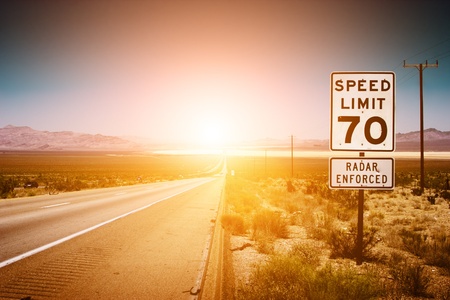 Highway road to sunset. 70 MPH speed limit sign.の写真素材