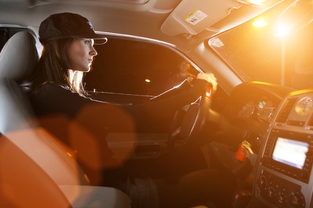 Beautiful young woman driving car at nightの写真素材