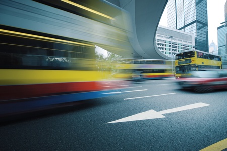 Long exposure photo of bus moving on urban road. Motion blur over city background. Cross processed colors.の写真素材