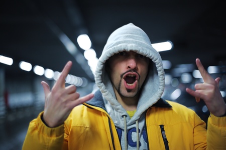 Portrait of young man in hoodie showing intimidating gesture. Shallow DOF.の写真素材
