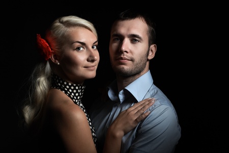 Portrait of young couple in love together on dramatic black background.の写真素材