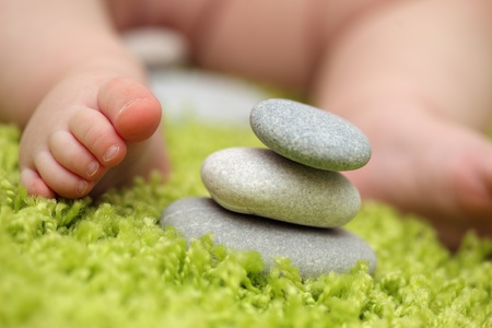 Baby feet next to stack of zen stones. Closeup, shallow DOF.の写真素材