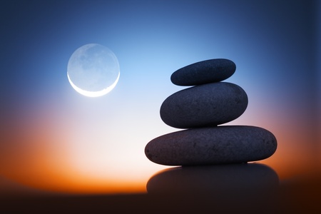 Stack of zen stones over sunrise sky background with moon.の写真素材