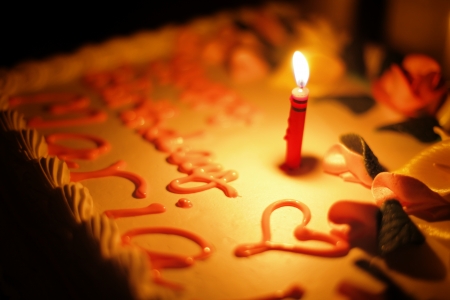 Birthday cake with burning candle. Shallow DOF.の写真素材