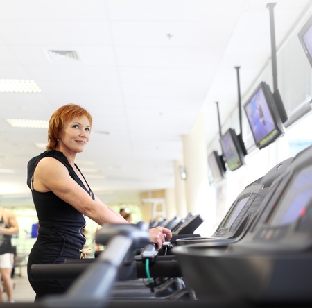 Mature woman exercising on treadmill in gym. Copyspace.の写真素材