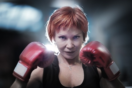 Portrait of mature woman in boxing gloves looking at camera. Closeup.の写真素材