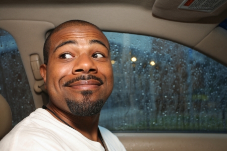 Cute smiling African American man driving car.の写真素材