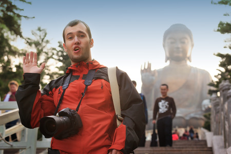Happy caucasian tourist near Big Buddha statue landmark at Lantau Island,Hong Kong, China. Asia.のeditorial素材