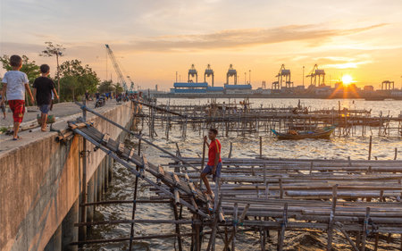 Unidentified people walking on bamboo bridge at sunsetの写真素材