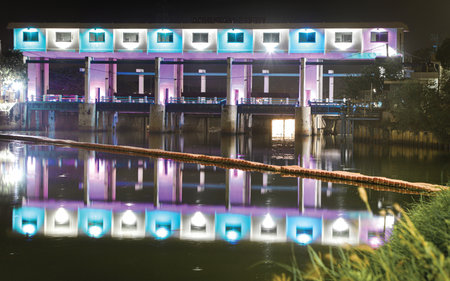 Night view of a building with lights and reflections on the water.の写真素材