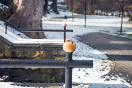 Detail of an old, steel, handrail in a park covered with snow during sunny day, Mikolow, Poland