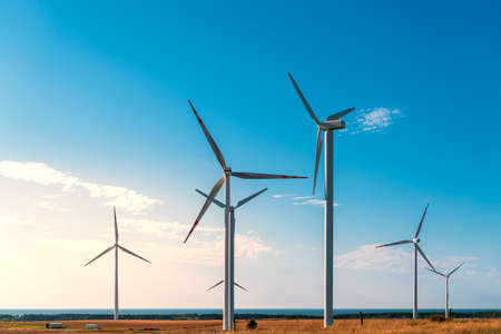 Windmills generating electricity located on a hill in the coastal area, the Baltic Sea in the background, wind farm against the blue sky, Poland Europeの写真素材