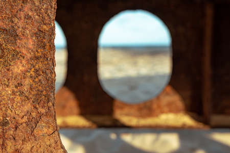 Rusty beams of the bridge located on the Baltic Sea, view of the beach on a sunny dayの写真素材