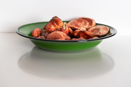 red pine mushrooms in a green bowl on a white background