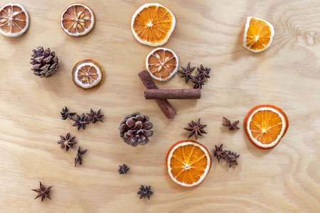 Christmas composition made of cones, dried oranges and lemons, cinnamon and anise stars. Plywood in the background.の写真素材