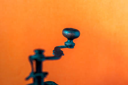 beautiful handle of the old coffee grinder on an orange backgroundの写真素材