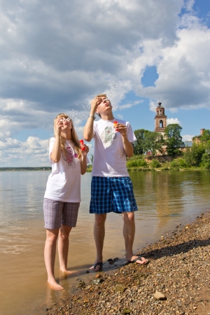 Beautiful girl walking with a young, confident guy on the river in the countrysideの写真素材