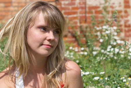 The beautiful girl sitting on the bank of the river on a sunny dayの写真素材