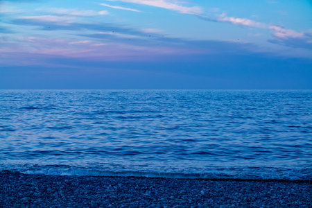 Enjoy the serene ocean view at dusk with peaceful waves and a stunning, naturefilled horizonの写真素材