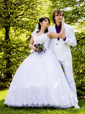 Elegant bride and groom posing together outdoors on a wedding dayの写真素材