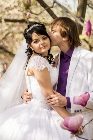 Newlyweds on nature background with blossoming magnoliasの写真素材