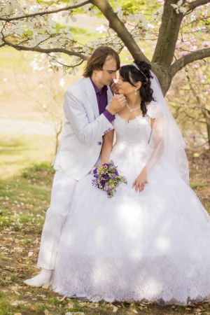 Bride and groom with a bouquet of kisses on the natureの写真素材