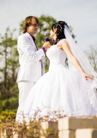 Elegant bride and groom posing together outdoors on a wedding dayの写真素材