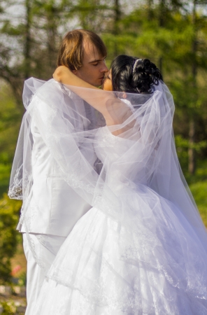 Bride and groom with a bouquet of kisses on the natureの写真素材
