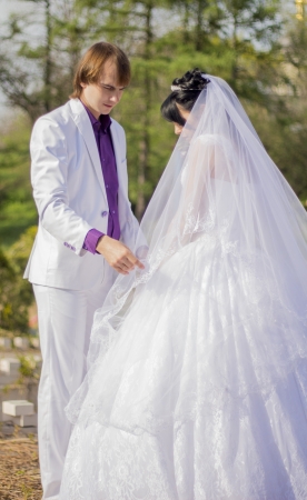 Elegant bride and groom posing together outdoors on a wedding dayの写真素材