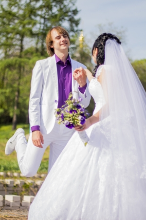 Newly married couple dancing in field. Outdoor portrait of bride and groomの写真素材