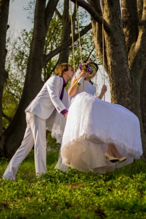 bride and groom swinging on a swingの写真素材