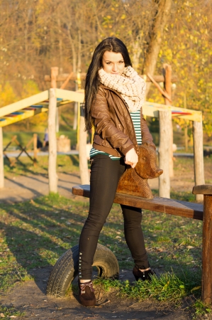 Smiling young model relaxing in a sunny garden sitting on swingの写真素材
