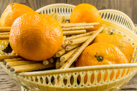 breadsticks and mandarins on wooden background