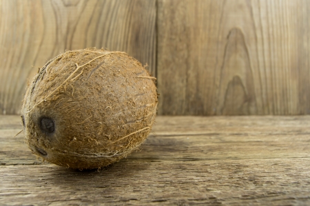 Whole fresh coconut over wooden backgroundの写真素材