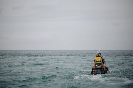 Girl and man, ride on the jet ski on the sea.の写真素材