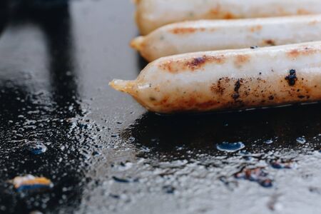appetizing juicy chicken sausages on the grill close-up.の写真素材
