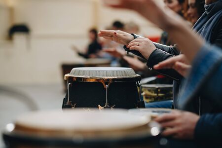 a large group of people play with African drums for the first time.の写真素材