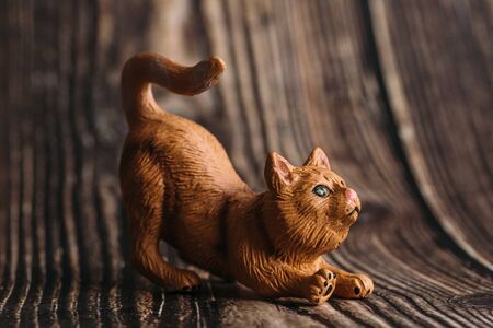 figure of a toy cat on a wooden background.の写真素材