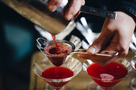 Close-up of expert bartender making red cocktail on the barの写真素材