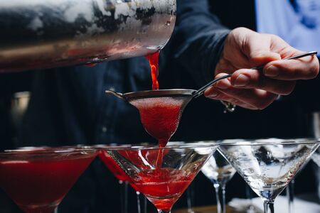 Close-up of expert bartender making red cocktail on the barの写真素材