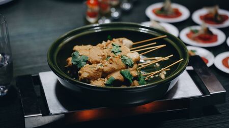 chicken skewers on wooden skewers in a green bowl closeupの写真素材