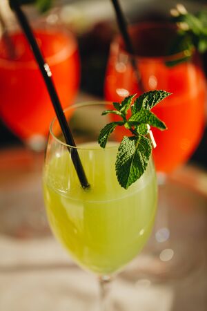 Summer cocktail drink in wine glass. Refreshing drink with mint leaves, gin tonic, syrop. Wooden background. Summer cocktail drink in wine glass.の写真素材