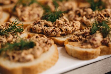 Beautifully decorated catering banquet table with different food snacks and appetizers with sandwich, caviar, fresh fruits on corporate christmas birthday party event or wedding celebration.の写真素材