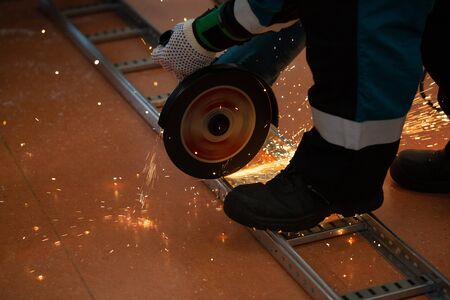 worker sawing metal with a saw, sparks fly.の写真素材