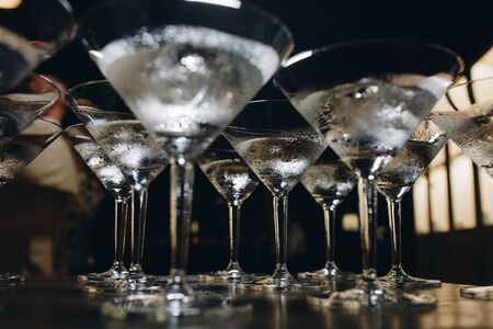 cocktail glasses with ice. the bartender cools the glasses before making cocktails.の写真素材