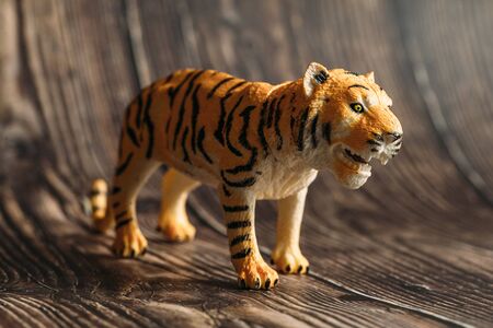figure of a toy tiger on a wooden background.の写真素材