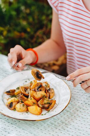 Woman eat fried potatoes. Woman eat fried and potatoes.の写真素材