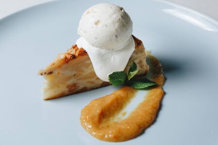 dessert pie with ice cream on a blue plate.の写真素材