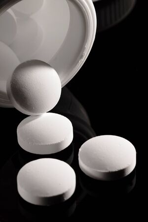 Pharmacy background on a dark table. Levitation pills. Tablets on a dark background which falling down. Pills. Medicine and healthy. Close up of capsules. Pills falling on black background&の写真素材